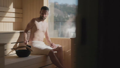 Mann macht in einer Panorama-Sauna einen Aufguss